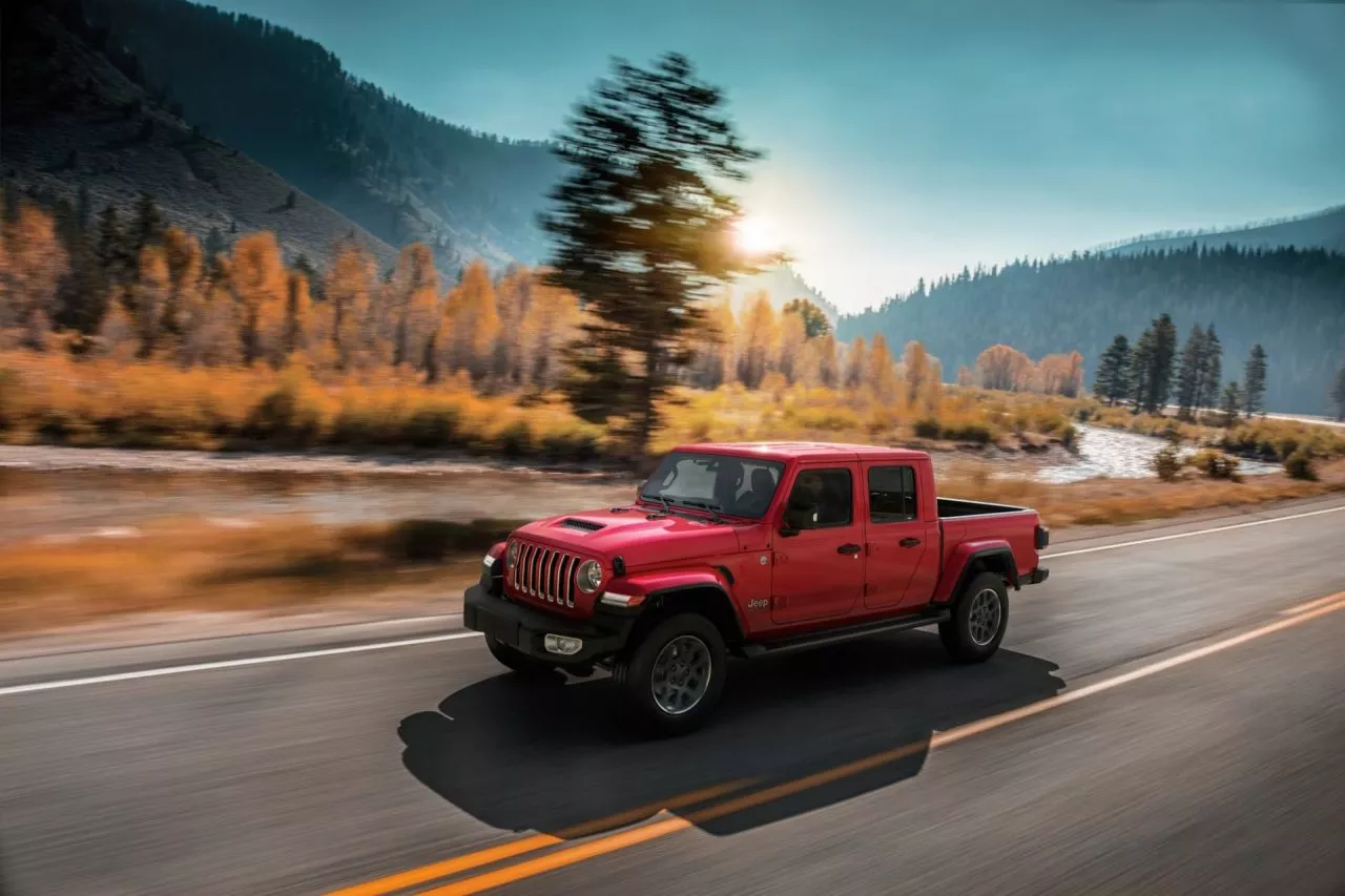 Vista dinámica del Jeep Gladiator en entorno natural, destacando su perfil robusto.