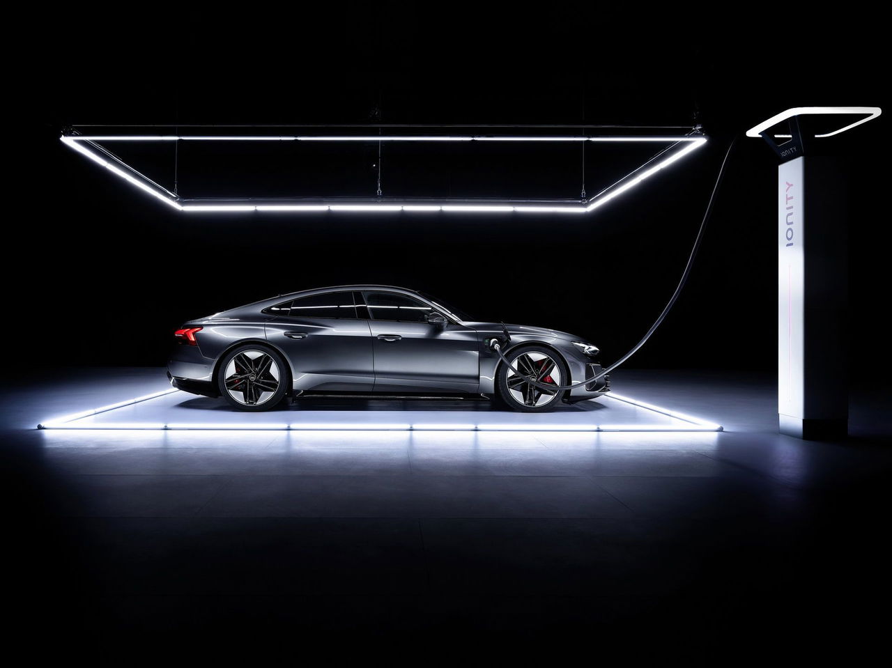 Vista lateral del Audi e-tron GT con iluminación destacando su silueta aerodinámica.