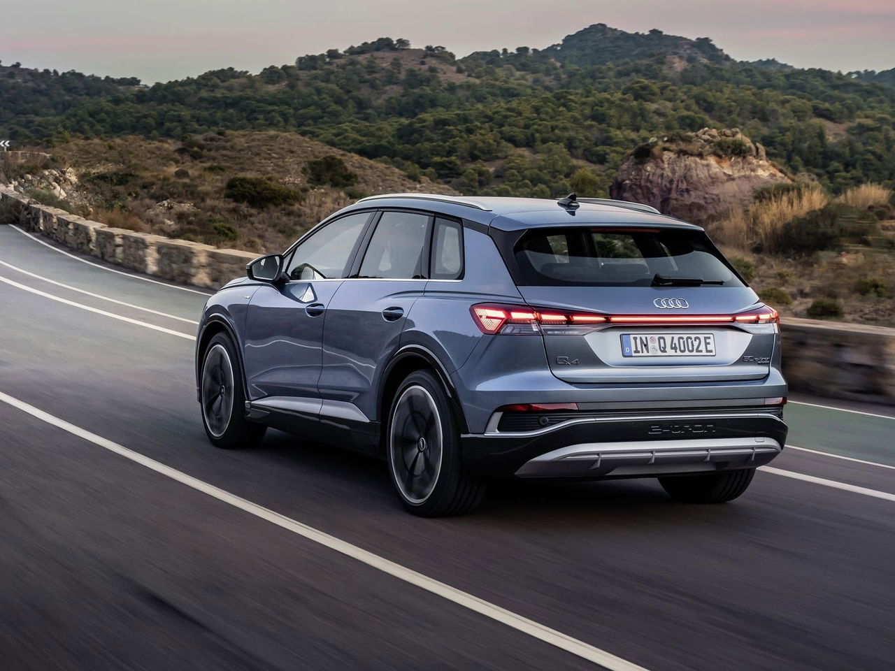 Vista dinámica de la trasera y lateral del Audi Q4 e-tron en carretera.