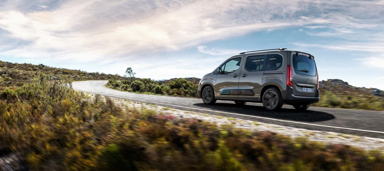 Vista lateral del Citroën Berlingo avanzando por un camino rural