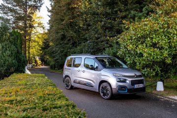 Vista lateral del Citroën Berlingo avanzando por un camino rodeado de vegetación.