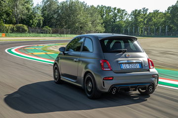 Vista dinámica del Abarth 595 en acción, destacando su trasera y lateral en pista.