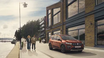 Vista dinámica del Dacia Jogger en un entorno urbano, destacando su diseño lateral.