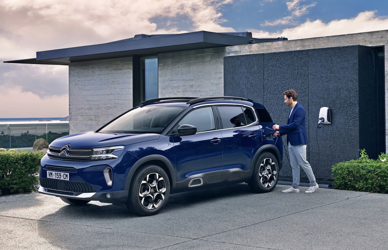 Vista lateral del Citroën C5 Aircross aparcado junto a una vivienda moderna.