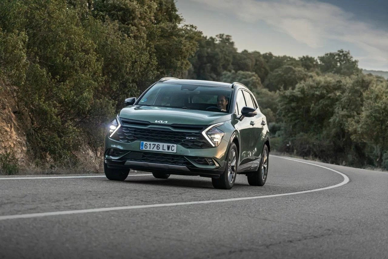 Vista dinámica del Kia Sportage en carretera, destacando su diseño frontal y lateral.