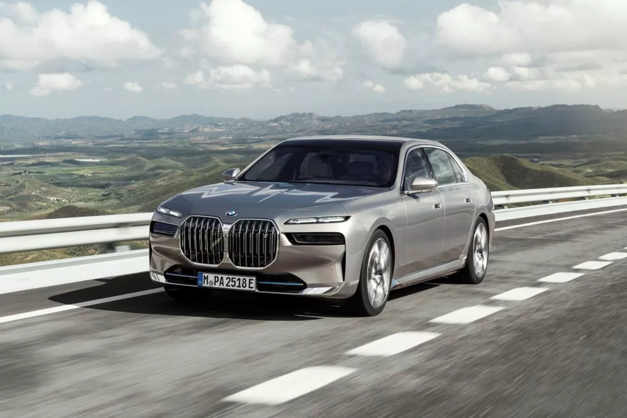 Vista dinámica del BMW i7 resaltando su frontal y línea lateral en carretera.