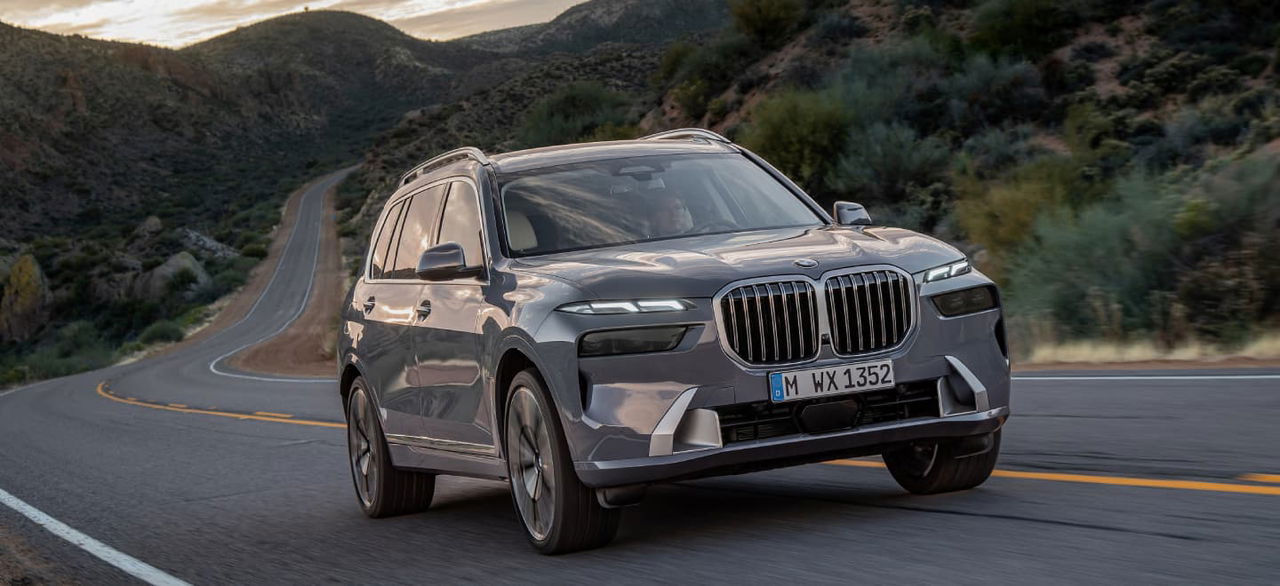 Vista dinámica del BMW X7 mostrando su imponente frontal y línea lateral.