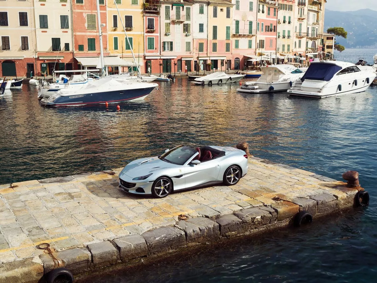 Vista lateral del Ferrari Portofino M parqueado en un muelle