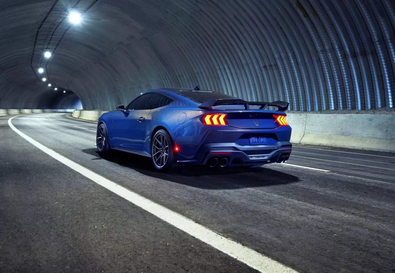 Vista trasera y lateral de un Ford Mustang iluminado en un túnel de noche