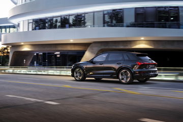 Perfil lateral del Audi Q8 e-tron capturado en un entorno urbano.