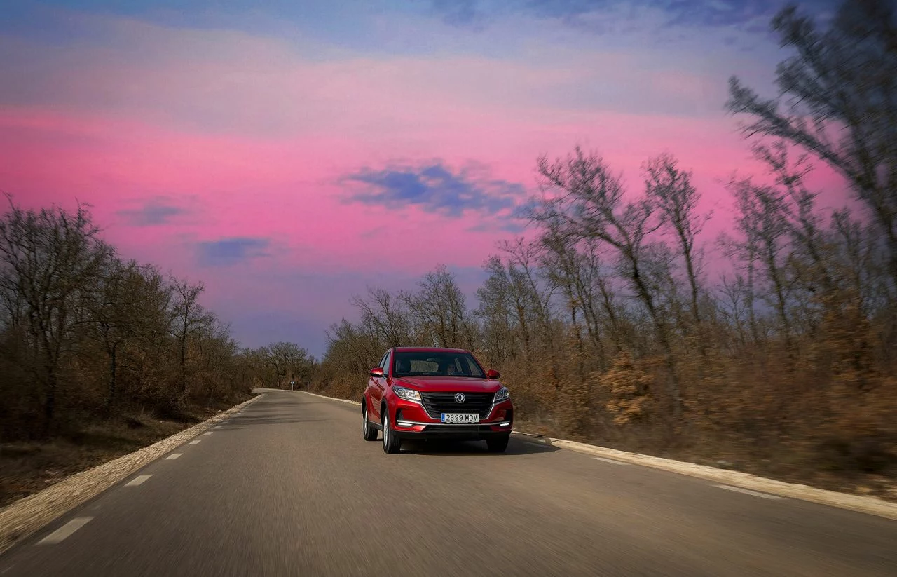 DFSK 500 en una carretera al atardecer, mostrando su diseño lateral y frontal.