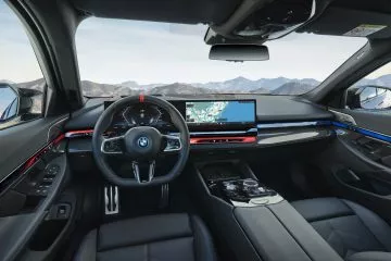 Vista del puesto de conducción del BMW Serie 5, destacando su tecnología y ergonomía.