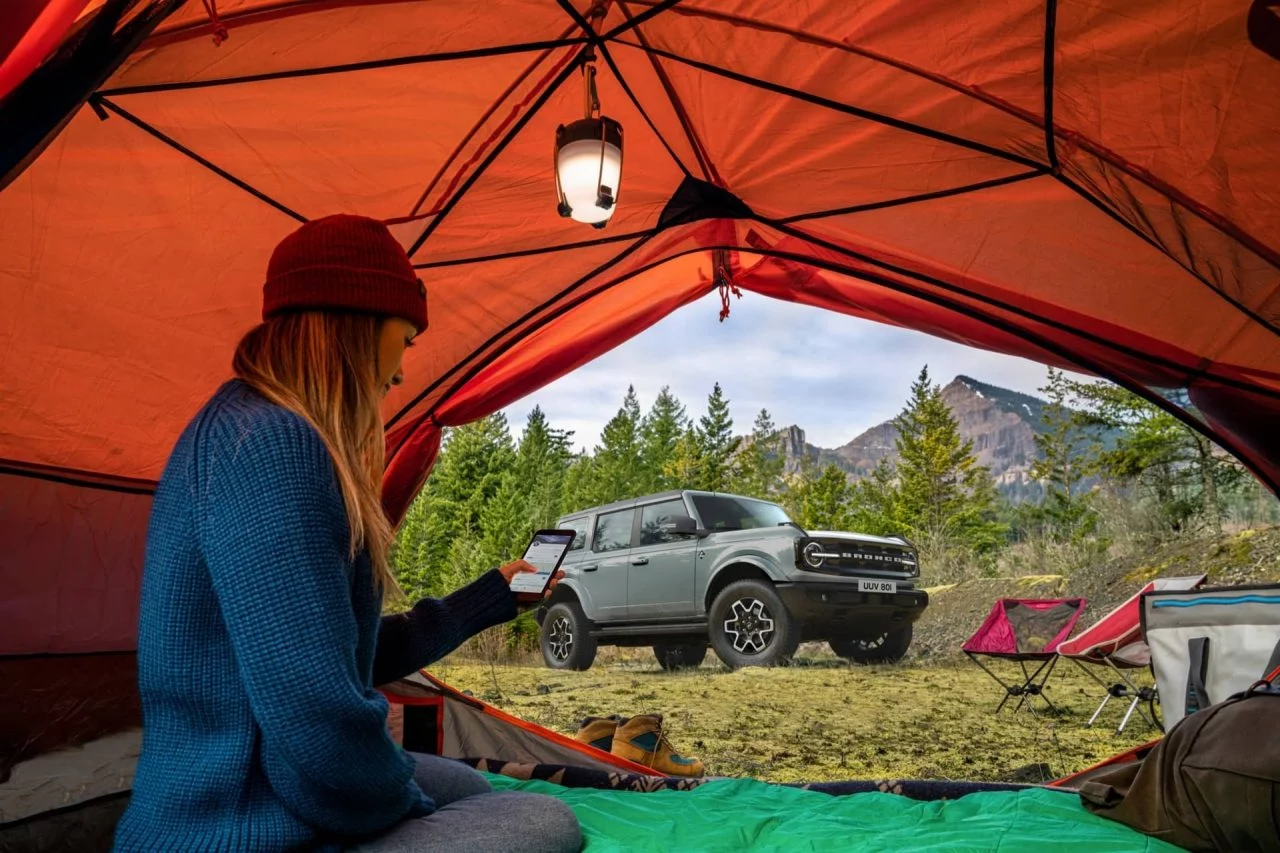 Vista lateral de un Ford Bronco desde una tienda de campaña en ambiente natural.