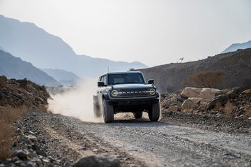 Vista delantera y lateral de un Ford Bronco superando terreno accidentado