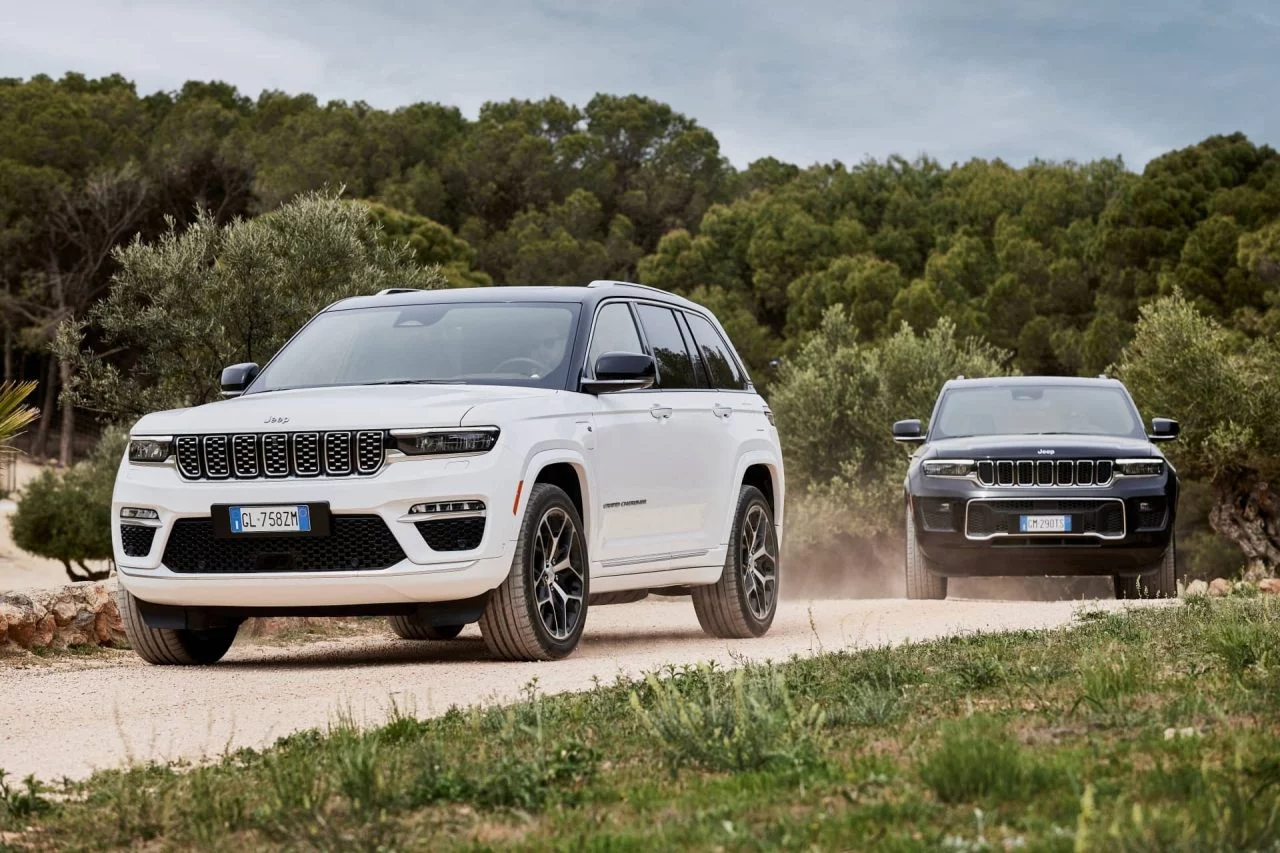 Dos Jeep Grand Cherokee avanzando por un camino de tierra.