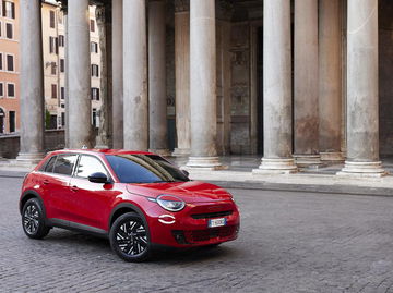 Vista del Fiat 600 en entorno urbano, mostrando su diseño frontal y lateral.