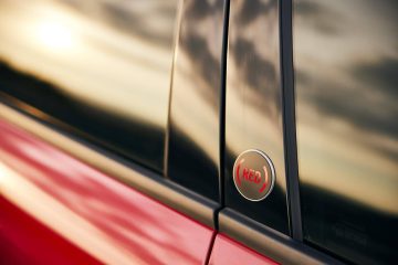 Detalle emblema Fiat 600 en costado, acabado cromado y rojo.