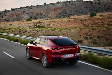 BMW X2 mostrando su diseño trasero y perfil lateral en carretera.