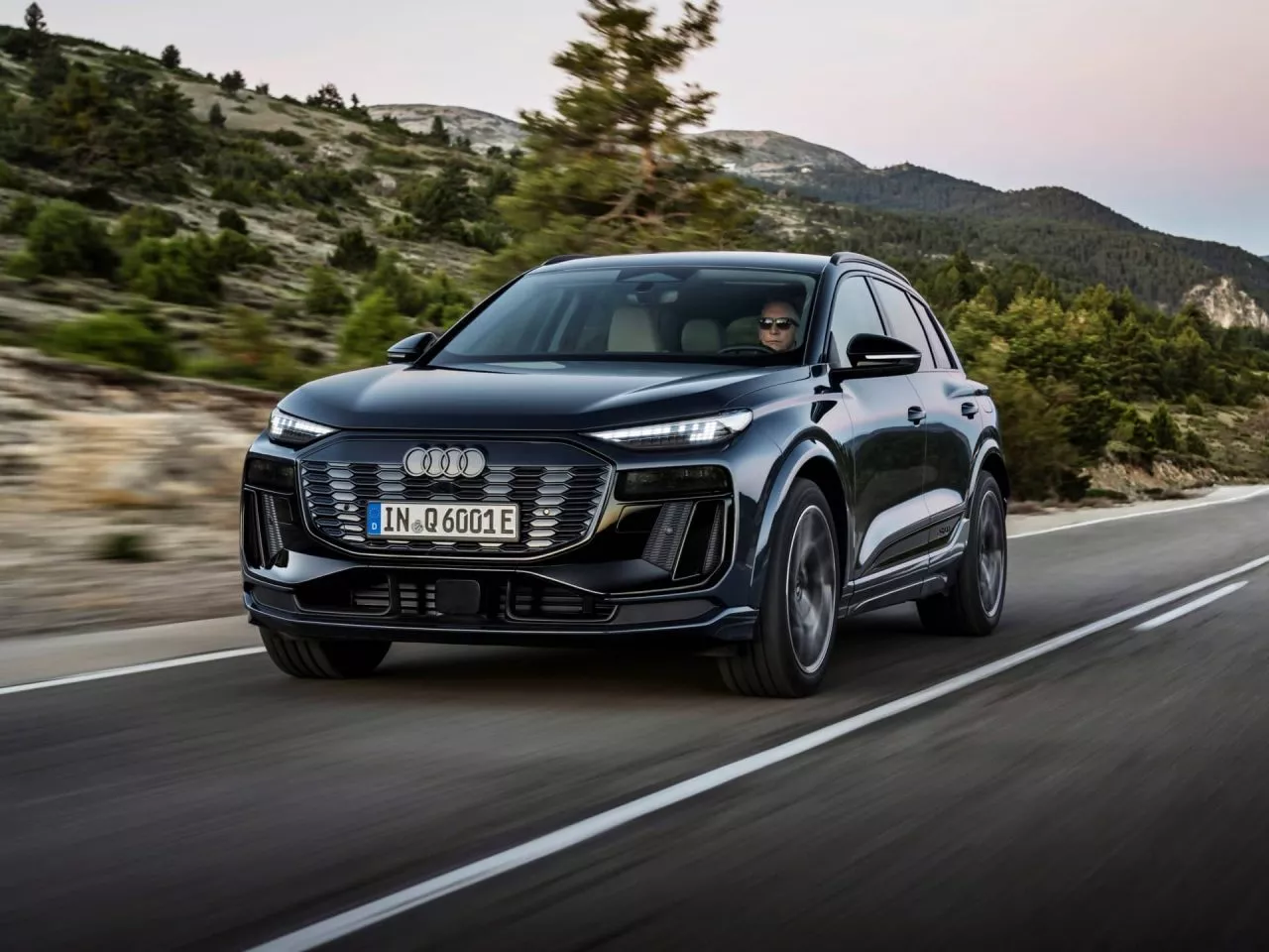 Vista dinámica del Audi Q6 e-tron en carretera, enfatizando su diseño frontal.