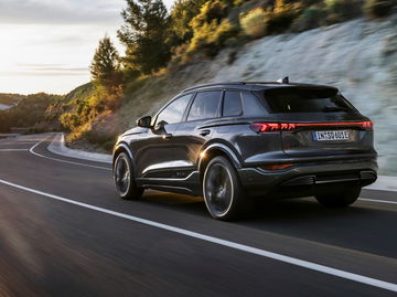 Vista dinámica trasera y lateral del Audi Q6 e-tron en carretera.