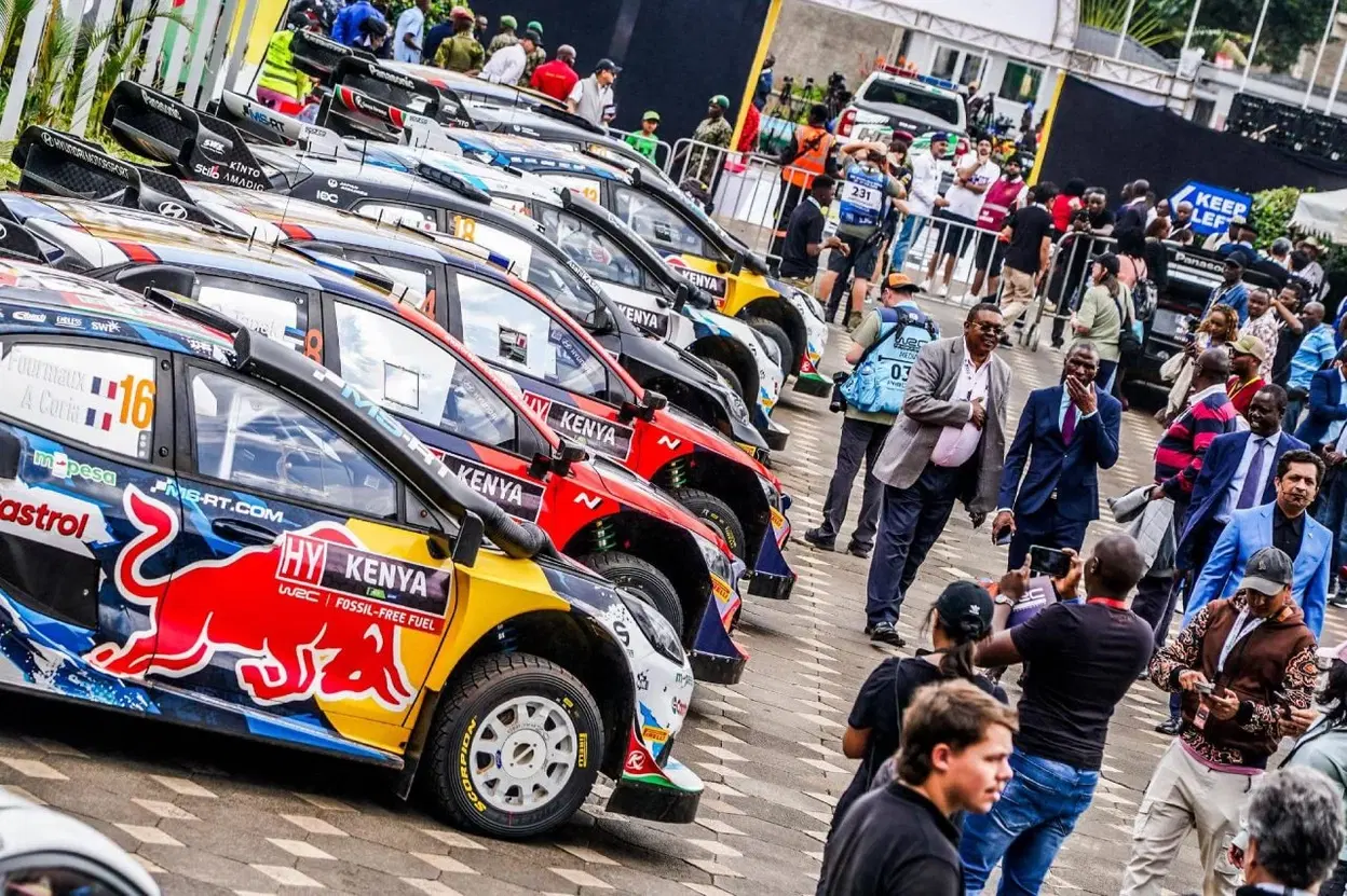 Vehículos de rally en línea preparados para la competición, mostrando la lateral con publicidad y decoración distintiva.