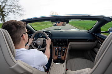 Vista del habitáculo delantero del Aston Martin DB12 Volante, destacando su elegante consola central