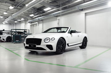 Vista lateral del Bentley Continental GT Convertible en una instalación industrial.