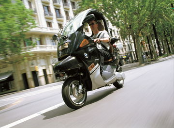 Vista dinámica lateral del BMW C1 en circulación por la ciudad.