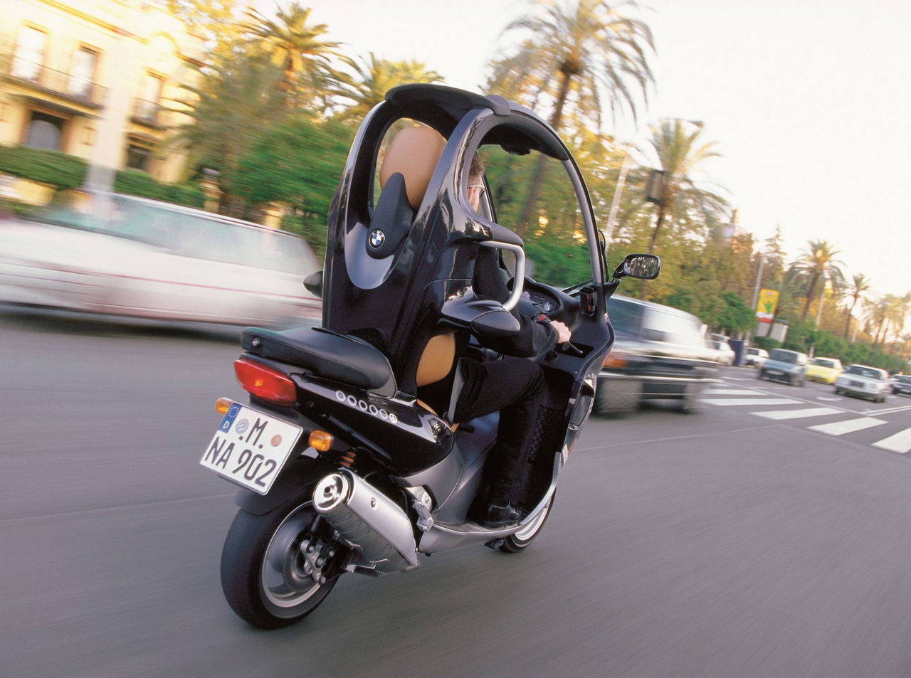 Vista dinámica del BMW C1 en circulación, mostrando su diseño lateral único.