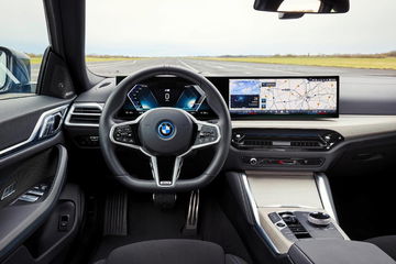 Cabina del BMW i4 eDrive mostrando volante, pantallas y consola central.