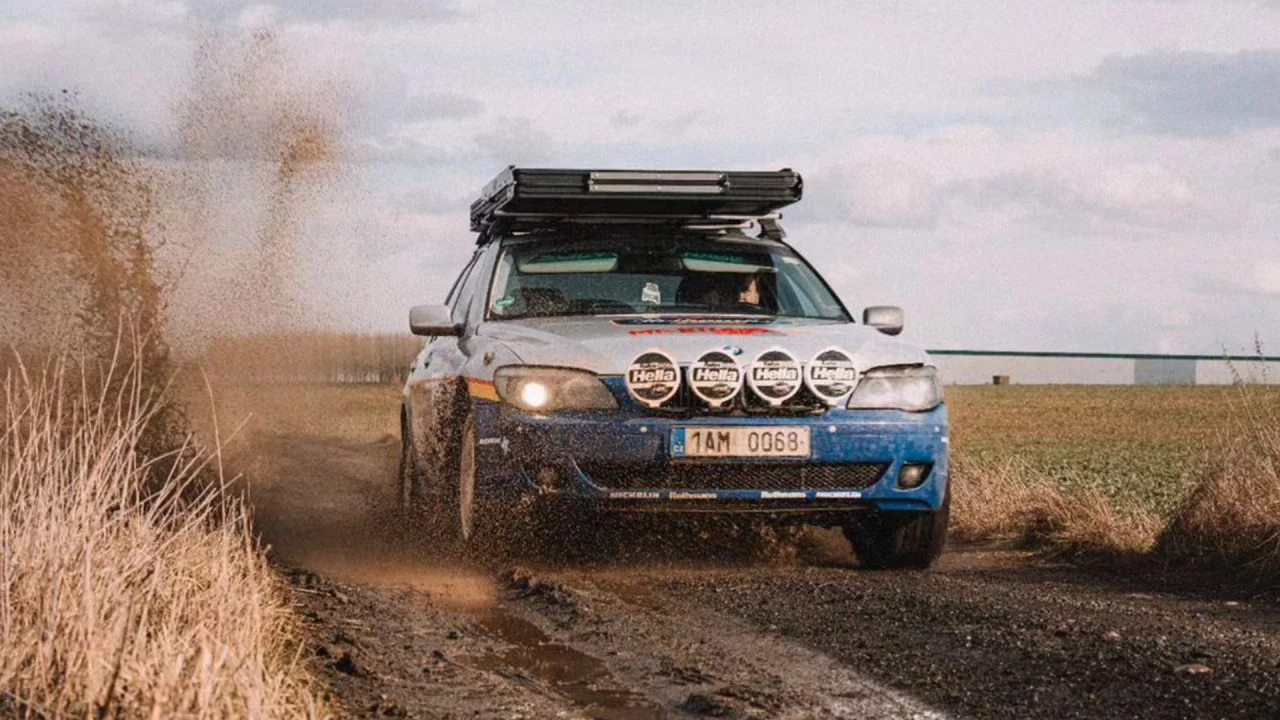 BMW Serie 7 modificado para terreno 4x4 en acción por un camino rural