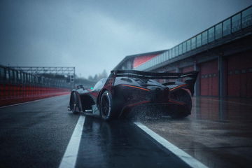 Vista posterior lateral del Bugatti en condiciones de lluvia, realzando su diseño aerodinámico y agresividad.