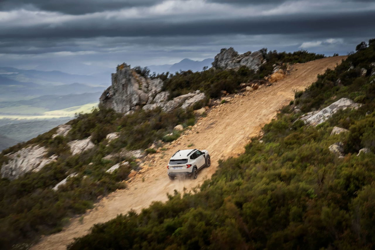 Dacia Duster ascendiendo por terreno montañoso, destacando su capacidad off-road.