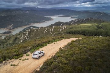 Vista lateral de un Dacia Duster en un camino de montaña, destacando su capacidad off-road.