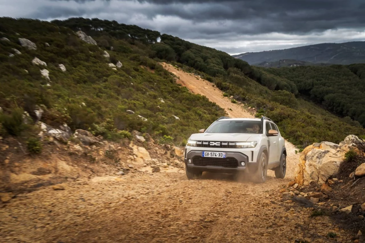 Dacia Duster superando terrenos irregulares, enfoque dinámico en ambiente natural.