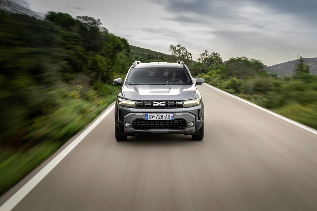 Vista frontal del Dacia Duster rodando sobre asfalto, realzando su robustez.