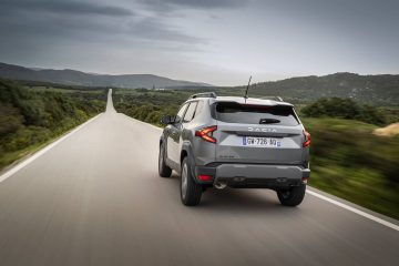 Vista trasera y lateral de un Dacia Duster en movimiento por una carretera.