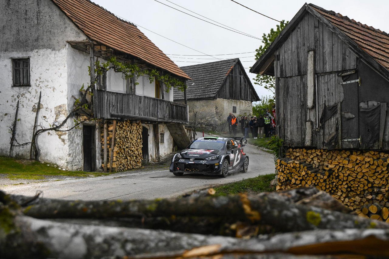 Vehículo de rally tomando una curva con destreza en un entorno rural