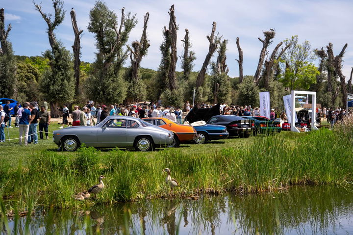 Concurso de elegancia automotriz con clásicos frente a estanque