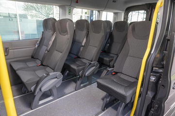 Vista de los asientos para pasajeros del Ford e-Transit Minibus, enfocando confort y capacidad.