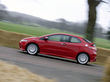 Vista dinámica de un Honda Civic en movimiento, destacando su línea lateral.