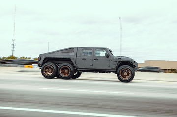 Hummer EV en movimiento, vista lateral, evidenciando su imponente diseño.