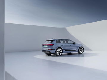 Audi Q4 e-tron capturado desde una perspectiva trasera lateral, resaltando su diseño y líneas modernas.