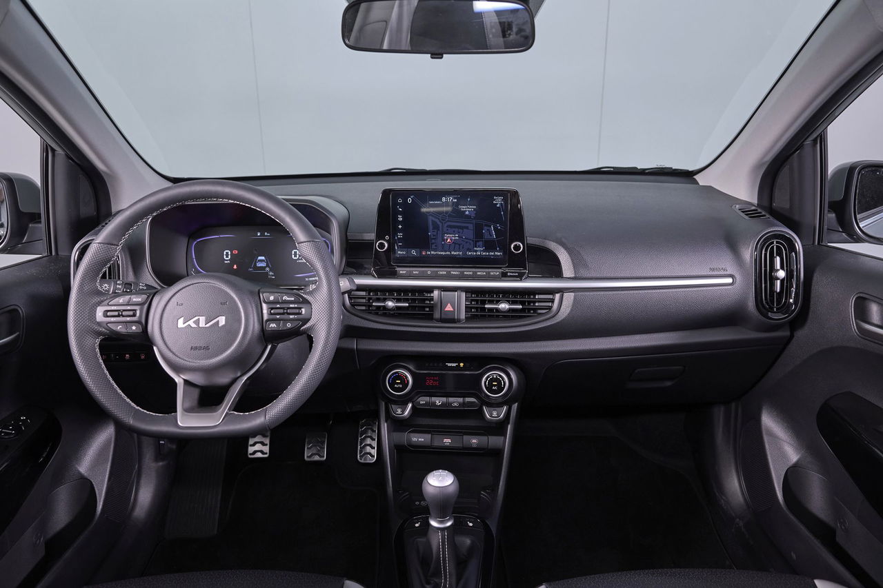 Vista frontal del habitáculo del Kia Picanto 2024, destacando su consola central y diseño ergonómico.