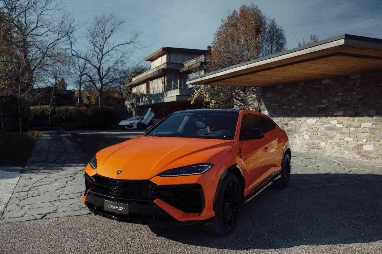 Lamborghini Urus SE 2024 en tono naranja vibrante, mostrando su perfil lateral y parte delantera.