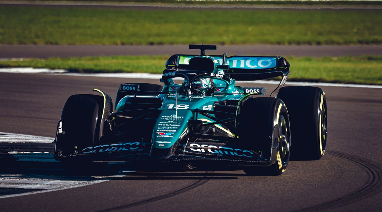 Vista dinámica del Aston Martin de F1 en acción, destacando aerodinámica y librea.