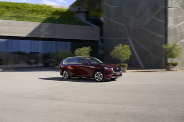 Elegante silueta del Mazda CX-80 en movimiento, acabado en rojo Artisan.