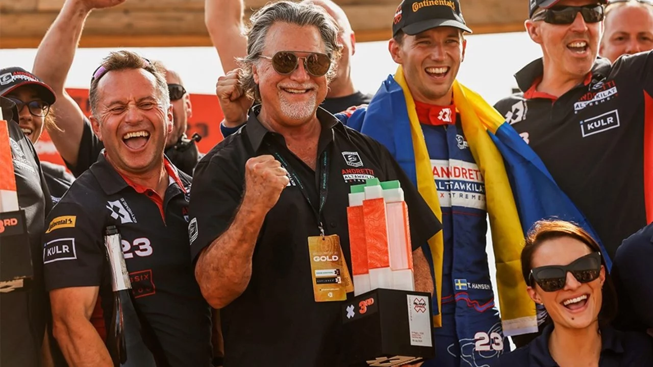 Michael Andretti con su equipo celebrando en el paddock