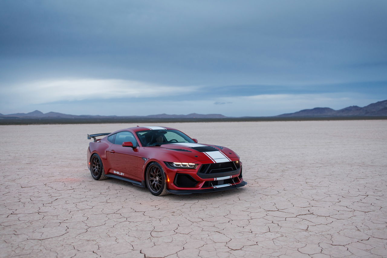 Vista frontal lateral de un Mustang Shelby GT500 posando en el desierto.