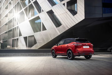 Vista trasera y lateral del Nissan Qashqai 2024 en color rojo, destacando su diseño moderno y deportivo.